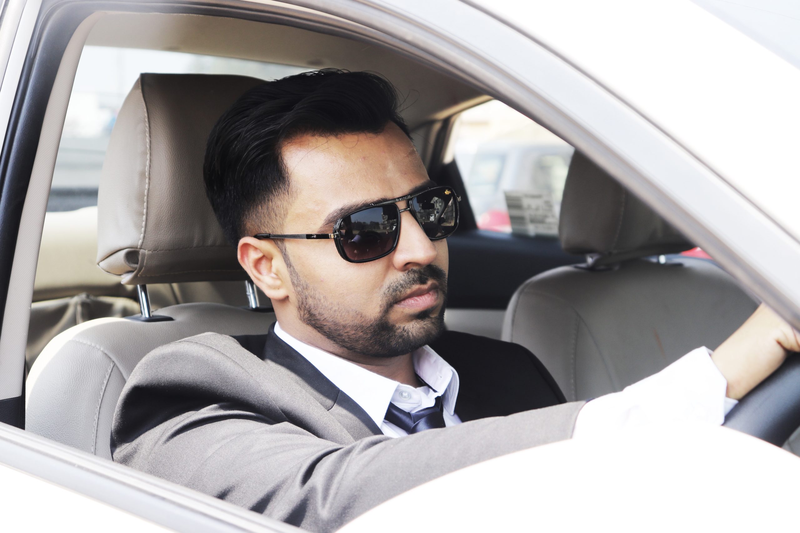 Bhavik Sharma Motivational Speaker sitting in his car scaled